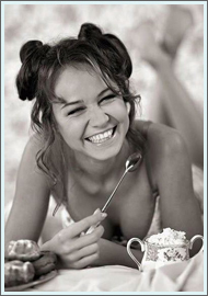 Изображение улыбающейся девушки с чашкой кофе и пирожным